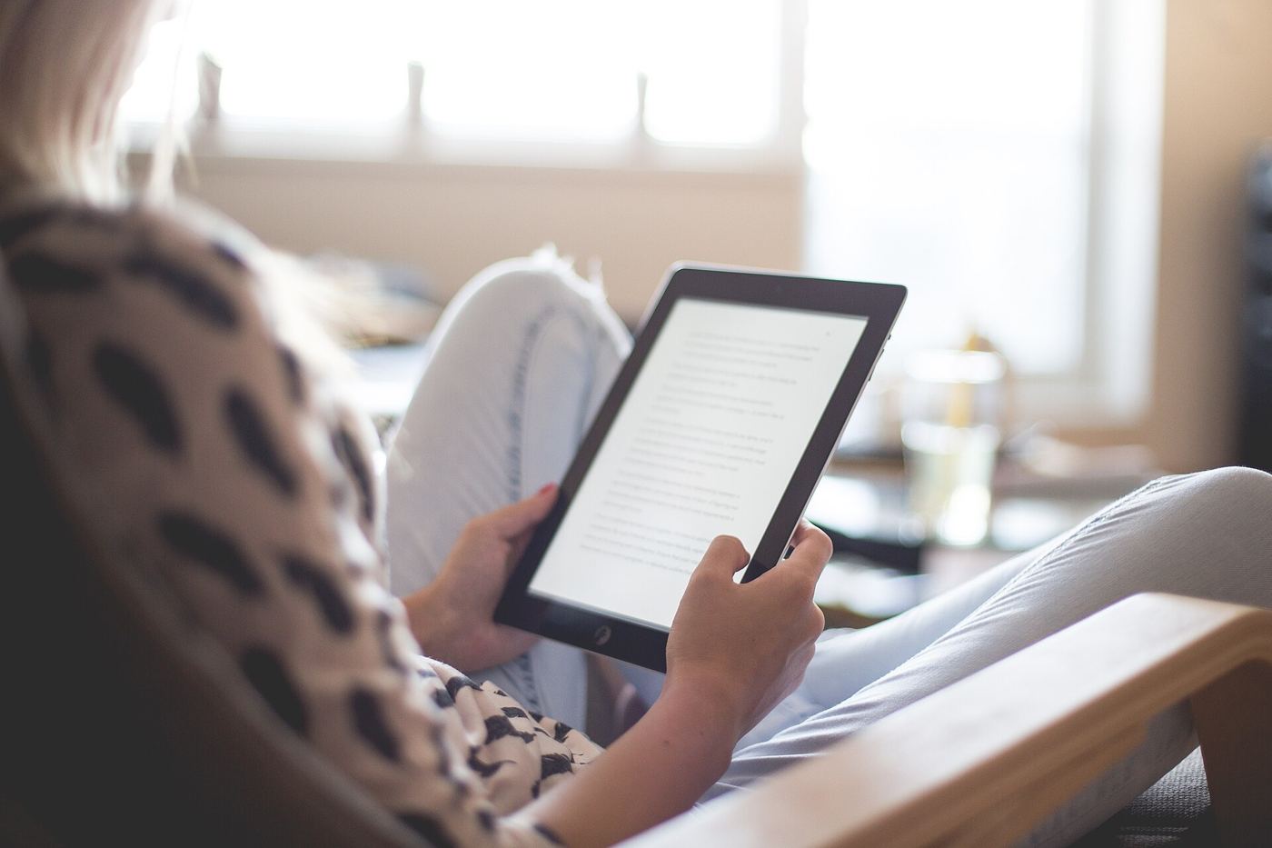 A young reader absorbed in an e-book on a phone during a train journey